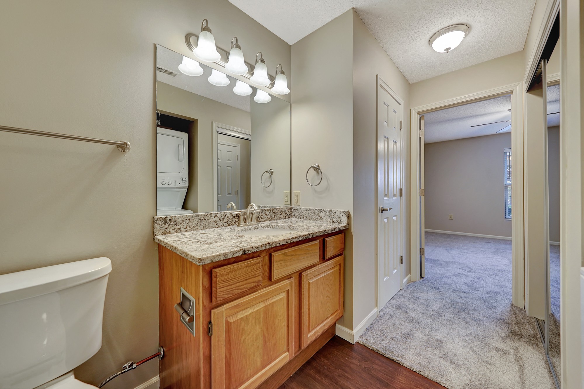 an empty bathroom with a large mirror and a toilet